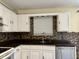 Kitchen detail featuring a stainless steel sink, tile backsplash, and countertop at 6903 Governors Pointe Blvd, Indianapolis, IN 46217