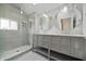 Beautiful primary bathroom with double vanity, stylish mirrors, and glass enclosed shower at 701 Lincoln St, Indianapolis, IN 46203