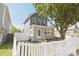 Charming two-story home featuring a brick foundation, inviting front porch, and a lovely white picket fence at 701 Lincoln St, Indianapolis, IN 46203