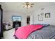 Bright bedroom with a ceiling fan, TV, sitting chair, and doorway to another room at 7157 Chemistry Ct, Indianapolis, IN 46239