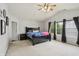 Bright bedroom with a ceiling fan, large windows, and dark wood furnishings at 7157 Chemistry Ct, Indianapolis, IN 46239