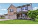 Charming two-story home featuring a brick facade, light gray siding, and a welcoming front porch at 7157 Chemistry Ct, Indianapolis, IN 46239