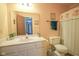 Vintage bathroom features a single vanity, toilet, and shower with patterned curtain at 7249 Tappan Dr, Indianapolis, IN 46268