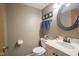 Cozy half bathroom with a decorative mirror, vanity, and toilet at 7249 Tappan Dr, Indianapolis, IN 46268