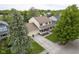 Aerial view of a two story home with front porch, a basketball hoop and mature trees at 7249 Tappan Dr, Indianapolis, IN 46268