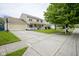 Exterior view of home featuring an attached garage, a long driveway, and a well-manicured lawn at 7249 Tappan Dr, Indianapolis, IN 46268