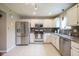 Well-lit kitchen features stainless steel appliances, white cabinets, and tile floors at 7249 Tappan Dr, Indianapolis, IN 46268