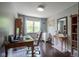 Bright office features a desk, comfortable chair, hardwood floors, and shelving at 7249 Tappan Dr, Indianapolis, IN 46268