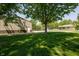 Green backyard with large shade tree, metal building, and home at 7285 E County Road 900 N, Brownsburg, IN 46112