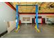 Garage space featuring a Titan two-post lift, overhead lighting, and red and black cabinets at 7285 E County Road 900 N, Brownsburg, IN 46112