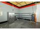 Well lit garage with an epoxy floor, a stainless steel fridge, metal shelves, and air compressor at 7285 E County Road 900 N, Brownsburg, IN 46112