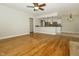 Spacious living room showcasing the hardwood floors, ceiling fan, and open kitchen concept at 7285 E County Road 900 N, Brownsburg, IN 46112