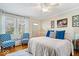 Cozy bedroom featuring hardwood floors, accent seating, and a ceiling fan with a light fixture at 744 Gilbert Ave, Indianapolis, IN 46227