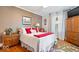 Bedroom with hardwood floors, neutral walls, bright windows with curtains, red decorative pillows and accents at 744 Gilbert Ave, Indianapolis, IN 46227