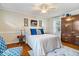 Bedroom featuring hardwood floors, neutral walls, ceiling fan, bright windows and a large wooden dresser at 744 Gilbert Ave, Indianapolis, IN 46227