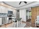 Kitchen featuring white cabinets, stainless steel appliances, dining table and chairs, and rustic sliding barn door at 744 Gilbert Ave, Indianapolis, IN 46227