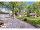 Expansive yard featuring a garage, additional structure, and gravel driveway surrounded by lush greenery at 744 Gilbert Ave, Indianapolis, IN 46227
