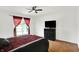 A bedroom with a ceiling fan, wood flooring, and a dresser with mounted television at 7642 Lancer Ln, Lawrence, IN 46226