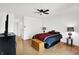 This comfortable bedroom includes wood floors, two bedside lamps, and a ceiling fan at 7642 Lancer Ln, Lawrence, IN 46226