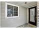 Covered front porch showcasing a door with decorative glass inserts and a window with white trim at 7642 Lancer Ln, Lawrence, IN 46226