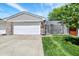 Attached two-car garage featuring a white door and brick siding, complemented by a well-kept lawn at 7642 Lancer Ln, Lawrence, IN 46226