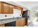 Kitchen featuring a stainless steel refrigerator, a double sink, wooden cabinets, and a sliding glass door at 7642 Lancer Ln, Lawrence, IN 46226
