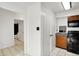 Kitchen area providing an open view into a bathroom and featuring black appliances and wooden cabinets at 7642 Lancer Ln, Lawrence, IN 46226