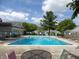 Community outdoor pool area with lounge chairs, greenery, and clear blue water for relaxation at 7642 Lancer Ln, Lawrence, IN 46226