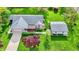 Aerial view showcasing the home's well-manicured lawn, mature trees, detached garage, and charming curb appeal at 7655 N Kitchen Rd, Mooresville, IN 46158