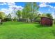 Expansive backyard with lush lawn, mature trees, and a charming storage shed at 7655 N Kitchen Rd, Mooresville, IN 46158