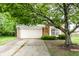 Charming brick home featuring a two-car garage and mature landscaping and healthy shade tree at 7703 Park North Lake Dr, Indianapolis, IN 46260