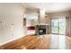 Open living room featuring hardwood floors, a stone fireplace, and sliding door at 7703 Park North Lake Dr, Indianapolis, IN 46260