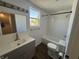 Modern bathroom with tiled tub and shower, gray vanity, and new light fixture at 810 S 18 Th St, Elwood, IN 46036