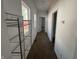 Hallway with neutral carpet, white walls, and a metal shelf unit at 810 S 18 Th St, Elwood, IN 46036