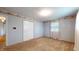 Neutral bedroom with carpet, a closet, window with curtains, and view into bathroom at 8630 E Mcgregor Rd, Indianapolis, IN 46259
