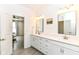 Bright bathroom with double sinks, white cabinets, and a view into the adjoining bedroom for seamless living at 89 Kinnick Dr, Greenwood, IN 46143