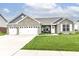 Charming brick home with a well-manicured lawn, three-car garage, and inviting front porch at 89 Kinnick Dr, Greenwood, IN 46143