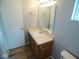 The bathroom boasts a vanity with a sink, a large mirror, modern fixtures, and wood-look flooring at 9125 Bagley Way, Indianapolis, IN 46231
