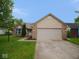 Charming single-story home with a brick and vinyl exterior, two-car garage and well-manicured lawn at 9125 Bagley Way, Indianapolis, IN 46231
