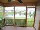 Screened-in porch with a view of a pond surrounded by greenery and neighborhood houses at 9125 Bagley Way, Indianapolis, IN 46231