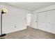 Bright bedroom features neutral carpeting, white walls and closet doors, and a modern style floor lamp at 917 Congressional Way, Shelbyville, IN 46176