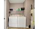Functional laundry room with side-by-side washer and dryer, utility shelving, and water heater at 917 Congressional Way, Shelbyville, IN 46176