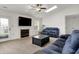 Comfortable living room featuring a fireplace, ceiling fan, and natural light from the skylight at 917 Congressional Way, Shelbyville, IN 46176