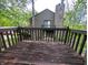 Exterior deck with wood railing overlooking the surrounding trees at 93 Lookout Ridge Dr # 24U, Columbus, IN 47201