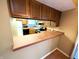 Kitchen with wood cabinets, tile countertop, breakfast bar, and modern appliances at 93 Lookout Ridge Dr # 24U, Columbus, IN 47201