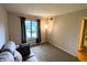 Bright living room with a window, neutral carpet, and comfortable seating at 93 Lookout Ridge Dr # 24U, Columbus, IN 47201
