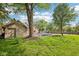 The backyard features mature trees, green grass, and a shed, with a pool, slide and basketball court in view at 101 Applecross Dr, Brownsburg, IN 46112