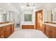 Bright bathroom featuring dual sinks, a shower, bathtub, natural lighting, and wooden cabinets at 101 Applecross Dr, Brownsburg, IN 46112