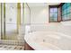 Bright bathroom featuring a glass shower, tile, and a large soaking tub at 101 Applecross Dr, Brownsburg, IN 46112