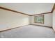 Bright bedroom featuring neutral carpet, wood trim, and a large window providing ample natural light and backyard views at 101 Applecross Dr, Brownsburg, IN 46112